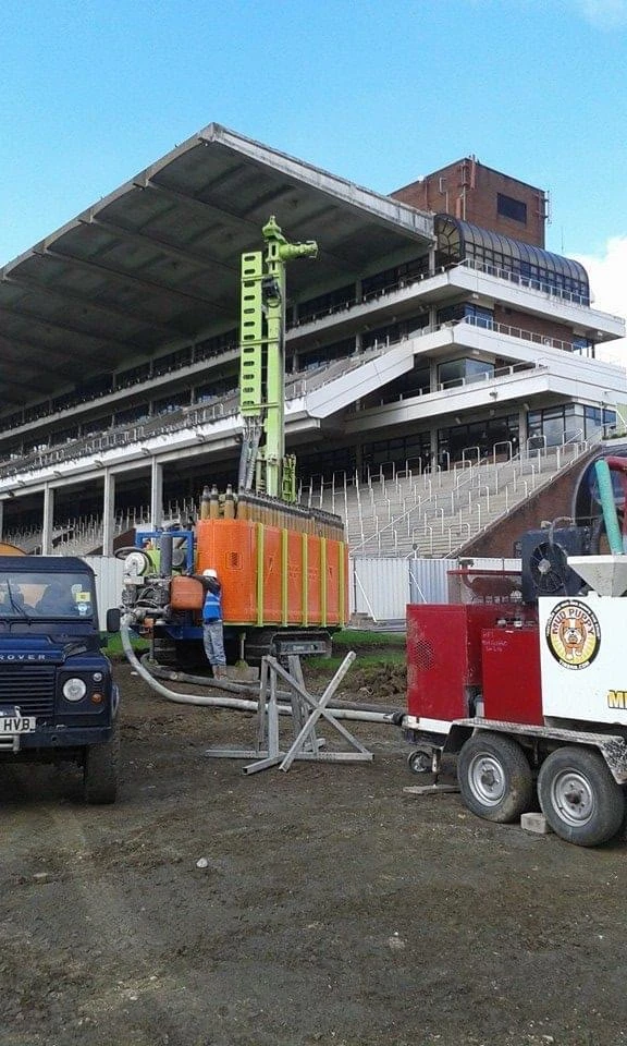 Drilling rig and support equipment beside a large grandstand